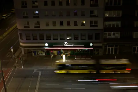 En buss lämnar en hållplats i Berlin på kvällen