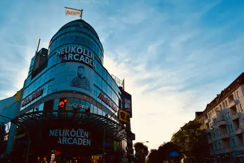 Karl-Marx-Straße och Neukölln Arcaden i skymningen
