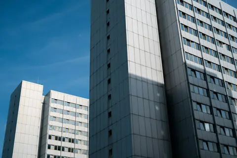 Två bostadshus under blå himmel i Berlin.