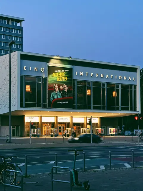 Kino International vid Karl-Marx-Allee i skymningen
