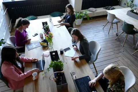 Grupp runt ett arbetsbord på CoWomen i Berlin