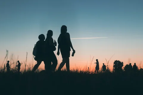 Människor promenerar på Tempelhofer Feld i solnedgången