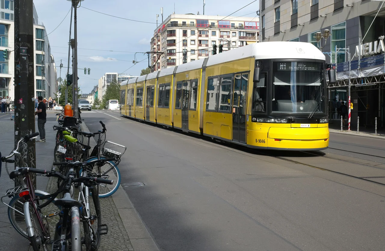 Gul spårvagn genom en gata i Berlin